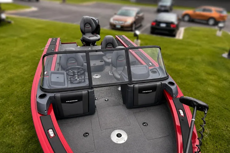 Slide: The Image of 2026 Tracker Targa V-19 Combo boat with red exterior, parked on grass. - 2