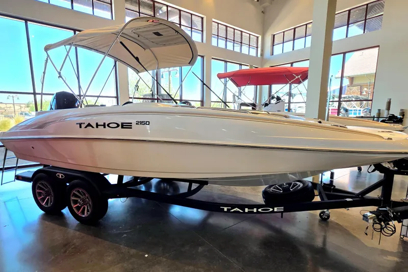 The Image of 2026 Tahoe 2150 boat displayed indoors on a trailer with canopy. - 0