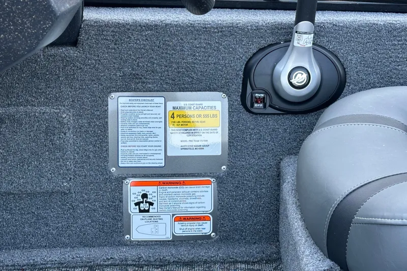 Slide: The Image of Control panel and seating of 2026 Tracker Pro Team 175 boat with safety labels. - 16