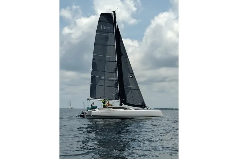 The Image of 2023 Corsair 880 sailboat on calm water under cloudy sky. - 0