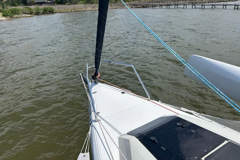 Slide: The Image of Sailing on a 2023 Corsair 880 trimaran, view from the deck over water. - 16