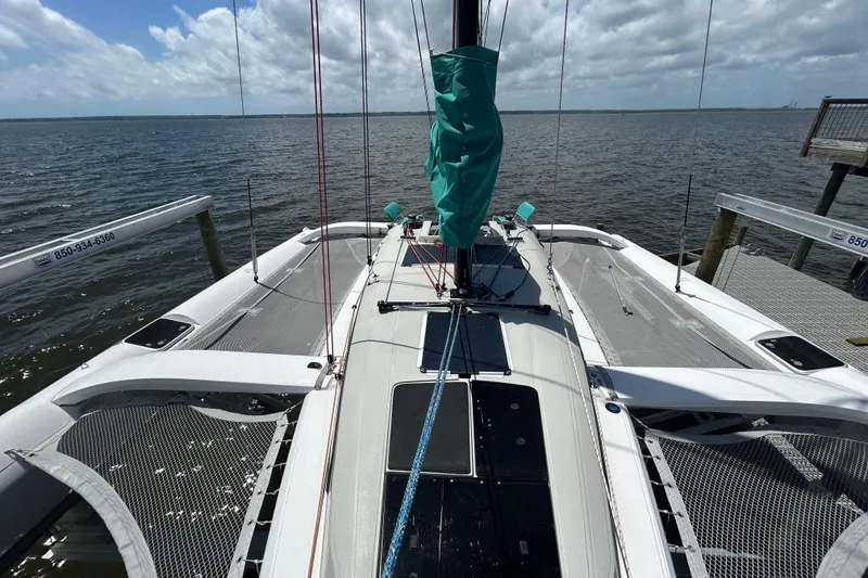 Slide: The Image of 2023 Corsair 880 sailboat docked, featuring sleek design and spacious deck. - 17