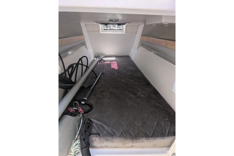 Slide: The Image of Interior cabin of 2023 Corsair 880 sailboat, featuring a cushioned sleeping area. - 22