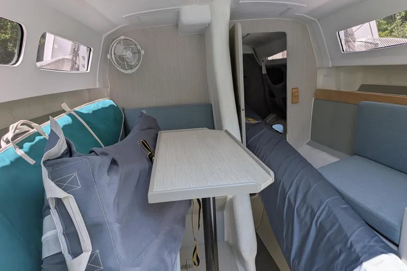 Slide: The Image of Interior of 2023 Corsair 880 sailboat, featuring seating, table, and compact cabin design. - 29