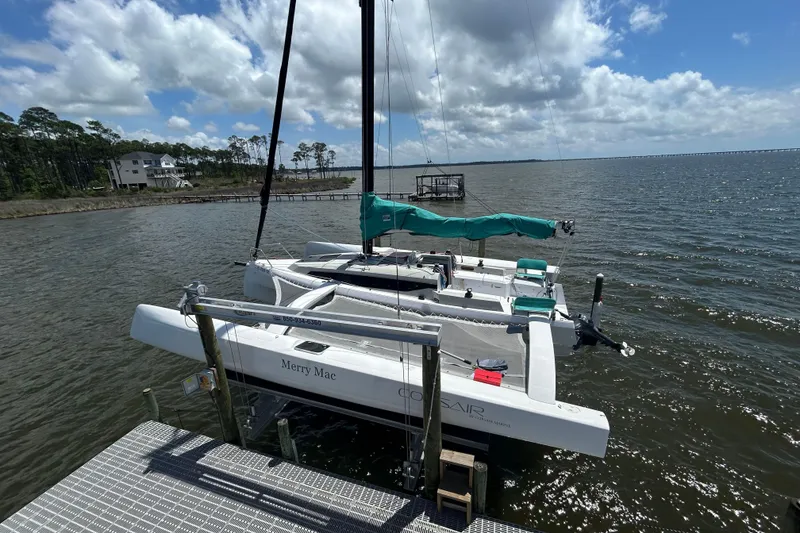 Slide: The Image of Sailboat Corsair 880 docked by the shore under a partly cloudy sky, 2023 model. - 3