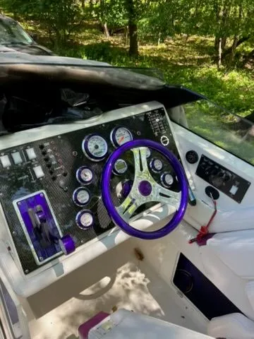 Slide: The Image of Dashboard of a 1998 Fountain 27 Fever boat with purple steering wheel. - 2