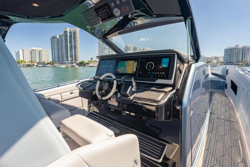 Slide: The Image of 2024 Cigarette 42' Auroris luxury boat cockpit with modern navigation displays, city skyline in background. - 32