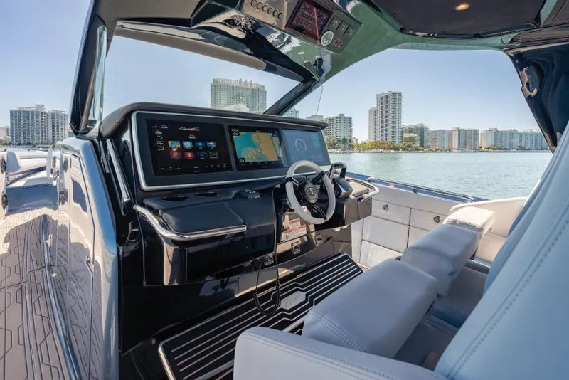 Slide: The Image of 2024 Cigarette 42' Auroris boat cockpit with modern navigation system and waterfront cityscape. - 33