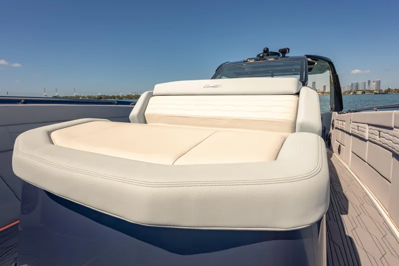 Slide: The Image of 2024 Cigarette 42' Auroris luxury boat with plush seating, docked near city skyline. - 42