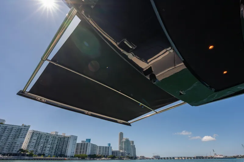 Slide: The Image of 2024 Cigarette 42' Auroris yacht with sunshade, city skyline in background. - 45
