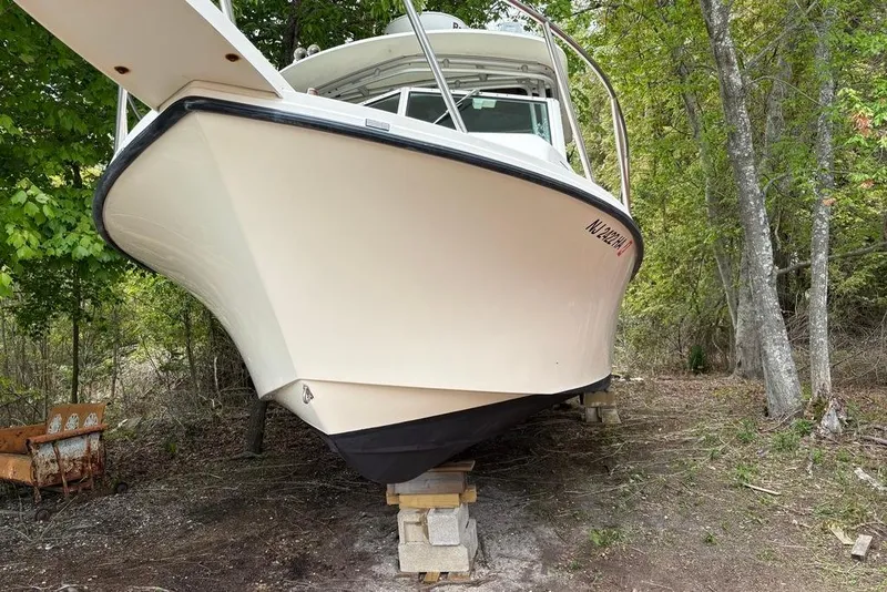 Slide: The Image of 2008 Parker 2510 XL Walkaround boat on blocks in wooded area. - 2