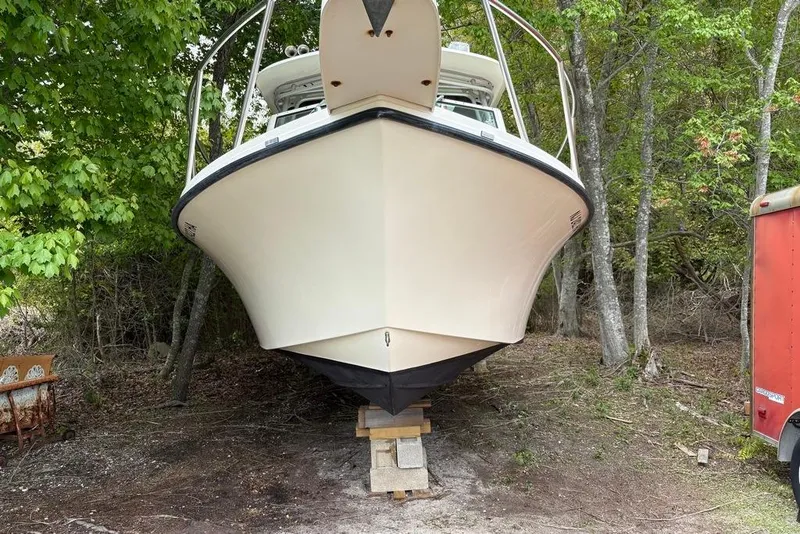 Slide: The Image of 2008 Parker 2510 XL Walkaround boat on blocks in wooded area. - 3