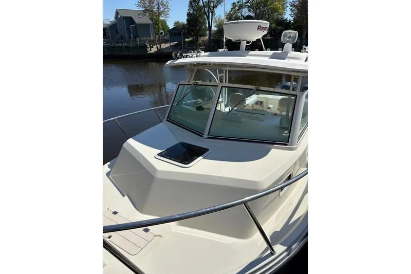Slide: The Image of 2008 Parker 2510 XL Walkaround boat docked by a calm river, featuring a sleek design. - 30