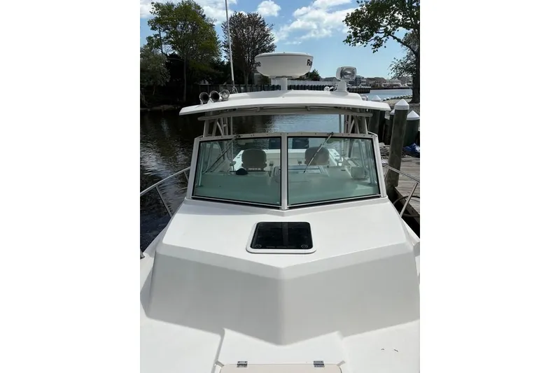 Slide: The Image of 2008 Parker 2510 XL Walkaround boat docked by a serene waterfront. - 31