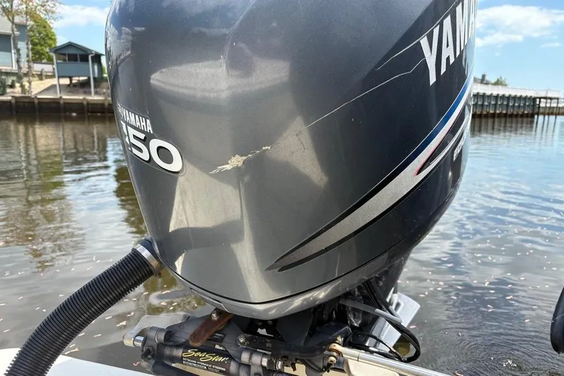 Slide: The Image of Yamaha 150 outboard motor on a 2008 Parker 2510 XL Walkaround boat by the water. - 32