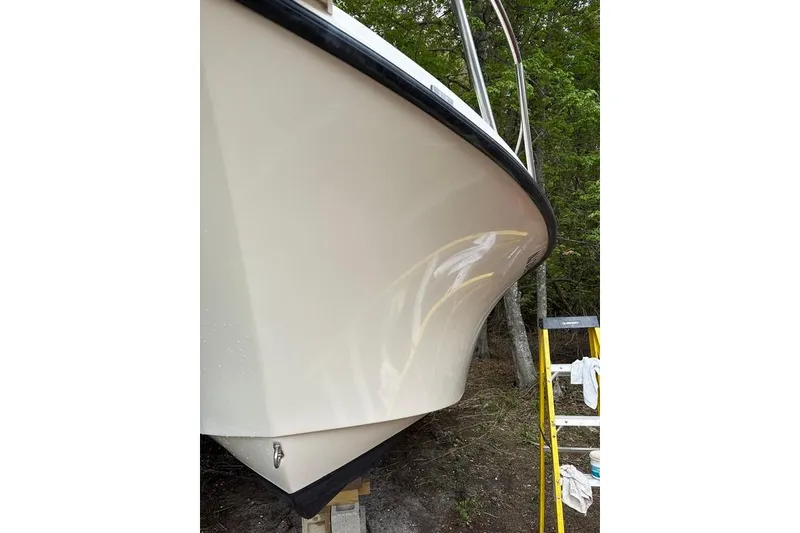Slide: The Image of 2008 Parker 2510 XL Walkaround boat hull, parked outdoors near trees. - 4