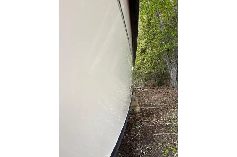 Slide: The Image of Side view of a 2008 Parker 2510 XL Walkaround boat on land. - 5