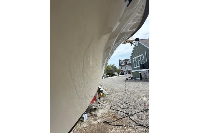 Slide: The Image of 2008 Parker 2510 XL Walkaround boat hull in a residential driveway setting. - 6