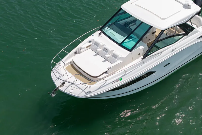 Slide: The Image of 2024 Sea Ray Sundancer 320 Outboard cruising on clear green water. - 13