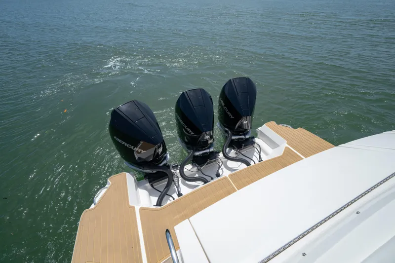 Slide: The Image of 2024 Sea Ray Sundancer 320 Outboard with triple Mercury engines on water. - 16