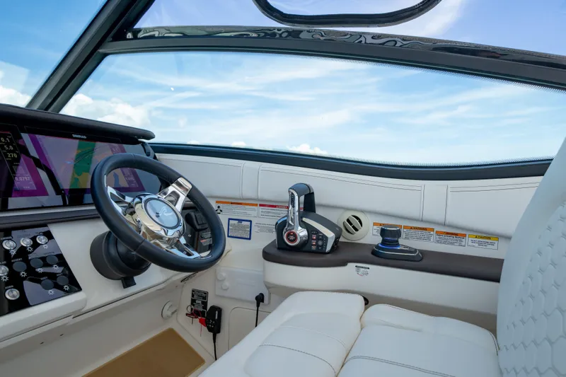 Slide: The Image of 2024 Sea Ray Sundancer 320 Outboard helm with modern controls and navigation displays. - 27