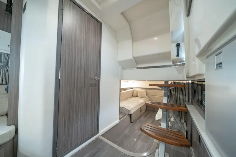 Slide: The Image of 2024 Sea Ray Sundancer 320 Outboard interior cabin with modern design and wooden steps. - 32