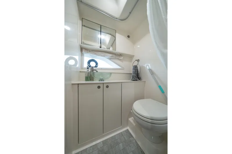 Slide: The Image of 2024 Sea Ray Sundancer 320 Outboard bathroom with modern fixtures and storage cabinets. - 34