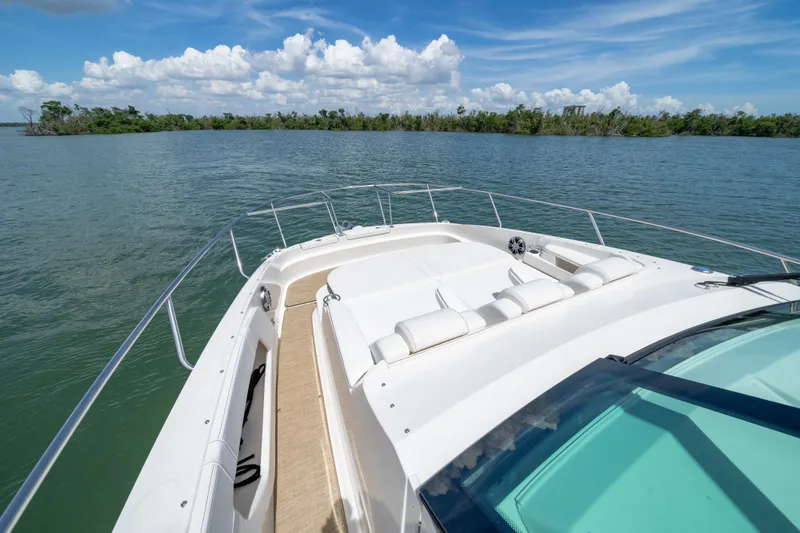 Slide: The Image of 2024 Sea Ray Sundancer 320 Outboard cruising on a serene lake under a blue sky. - 36