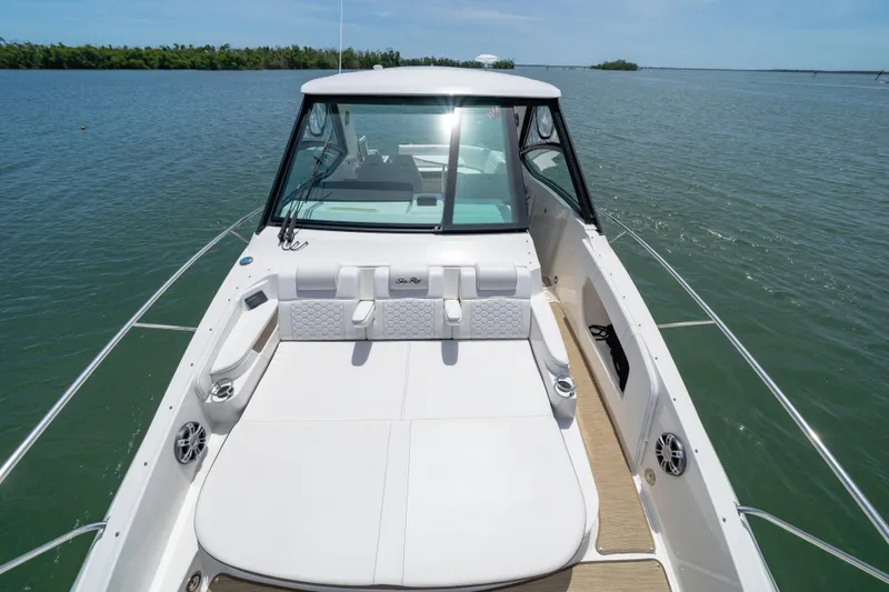 Slide: The Image of 2024 Sea Ray Sundancer 320 Outboard on calm water, showcasing spacious deck and seating. - 38