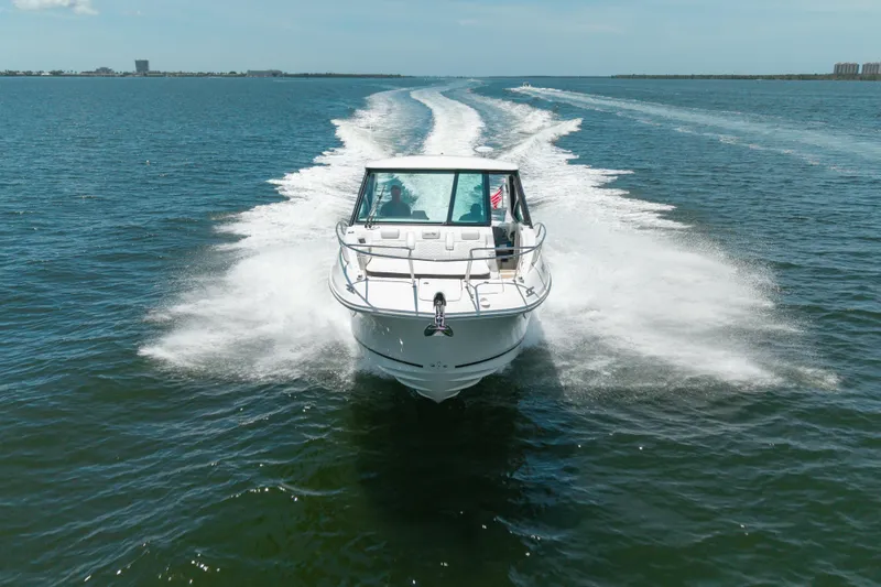 Slide: The Image of 2024 Sea Ray Sundancer 320 Outboard cruising on open water, leaving a wake trail. - 4