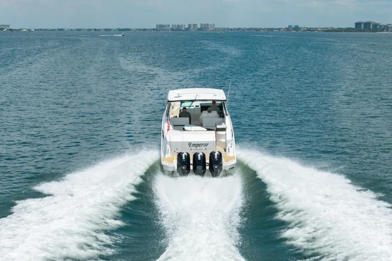 Slide: The Image of 2024 Sea Ray Sundancer 320 Outboard cruising on open water, rear view. - 6