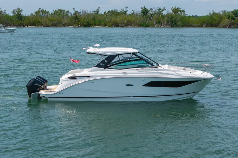 Slide: The Image of 2024 Sea Ray Sundancer 320 Outboard cruising on a serene lake. - 7