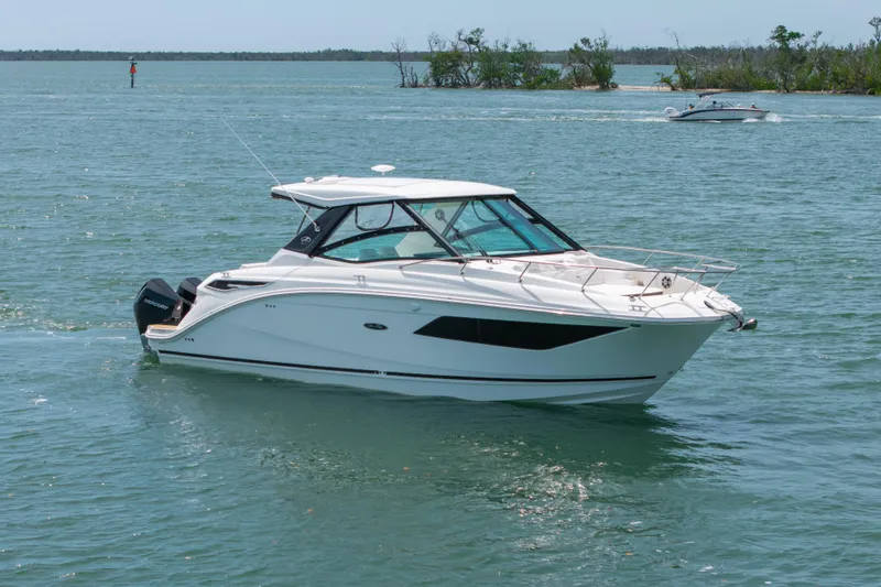 Slide: The Image of 2024 Sea Ray Sundancer 320 Outboard cruising on a serene waterway. - 9