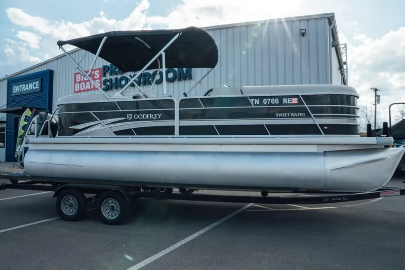 The Image of 2023 Godfrey Sweetwater 2286 SB pontoon boat on trailer outside showroom. - 0