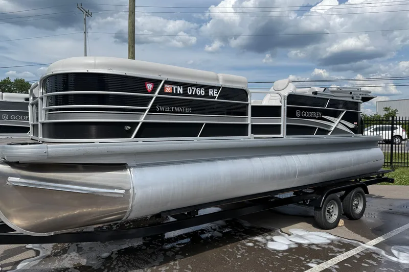 Slide: The Image of 2023 Godfrey Sweetwater 2286 SB pontoon boat on trailer under cloudy sky. - 1