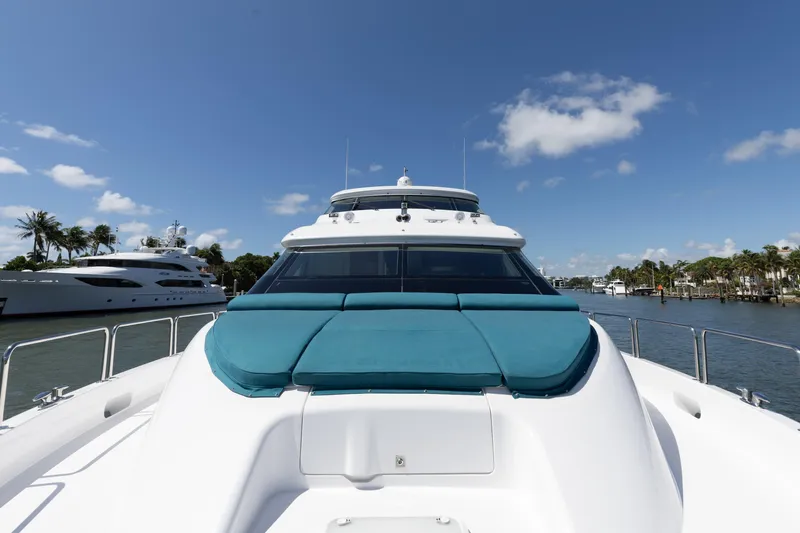 Slide: The Image of 2014 Hatteras 80 Motor Yacht Sky Lounge on a sunny day, docked near palm trees. - 12