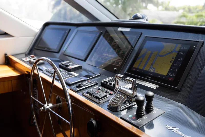 Slide: The Image of Control panel of 2014 Hatteras 80 Motor Yacht Sky Lounge with navigation screens and steering wheel. - 29