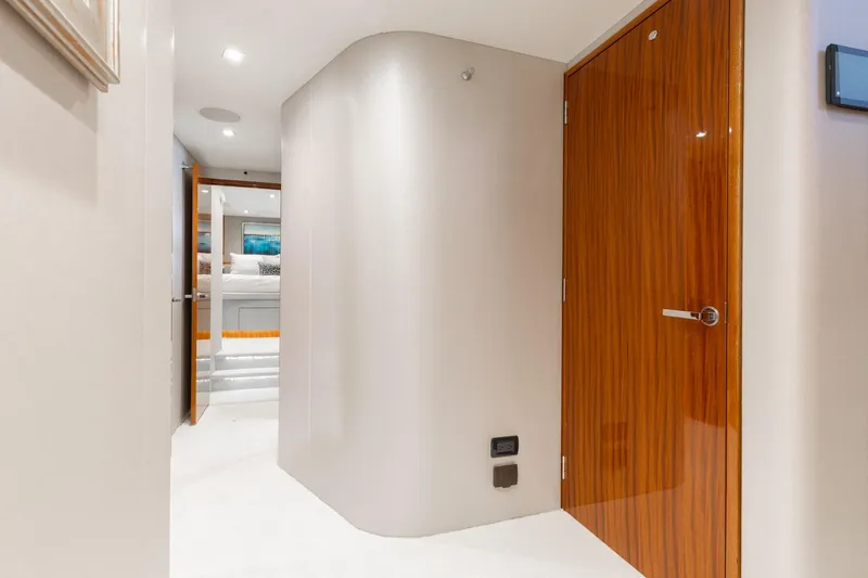 Slide: The Image of Hallway inside 2014 Hatteras 80 Motor Yacht Sky Lounge, featuring sleek wooden doors and modern design. - 35