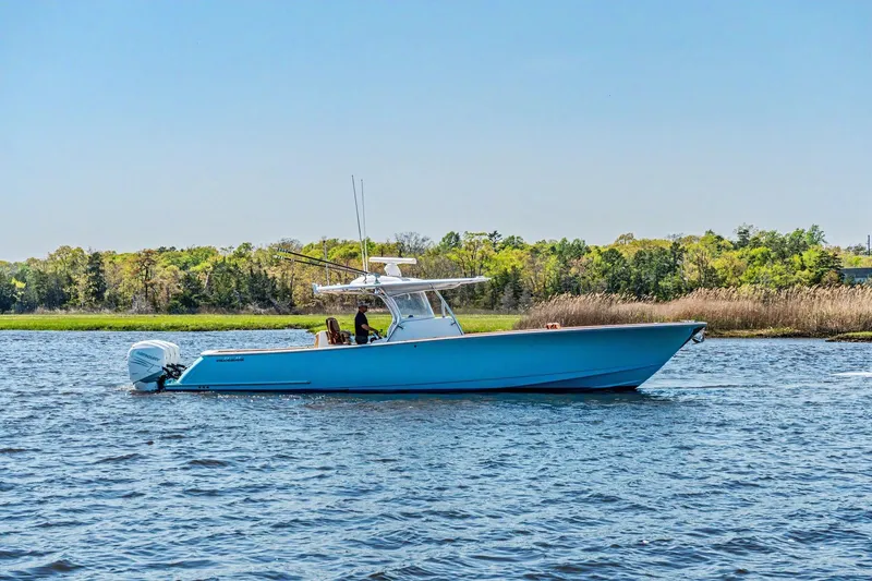 The Image of 2021 Valhalla Boatworks V-41 cruising on a serene lake with lush green shoreline. - 0