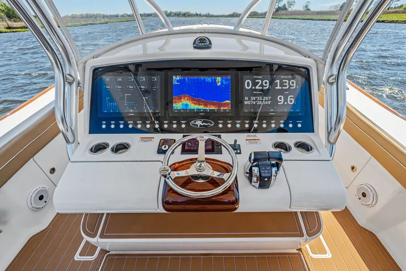 Slide: The Image of 2021 Valhalla Boatworks V-41 helm with advanced navigation displays on open water. - 15