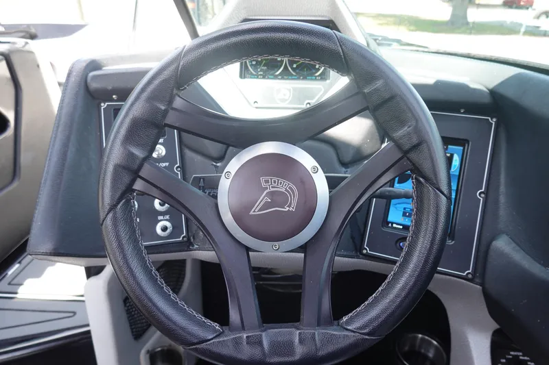 Slide: The Image of Steering wheel of a 2016 Centurion Enzo FS33 boat with dashboard controls. - 10