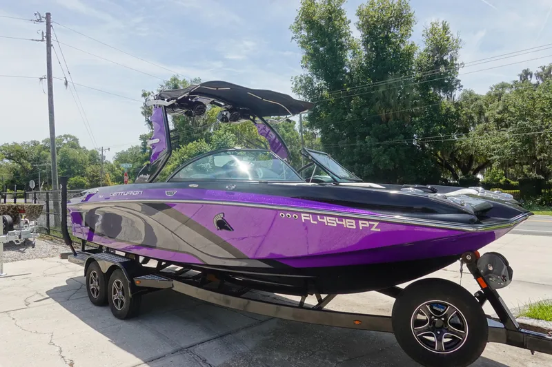 Slide: The Image of 2016 Centurion Enzo FS33 boat in vibrant purple on a trailer, parked outdoors. - 3