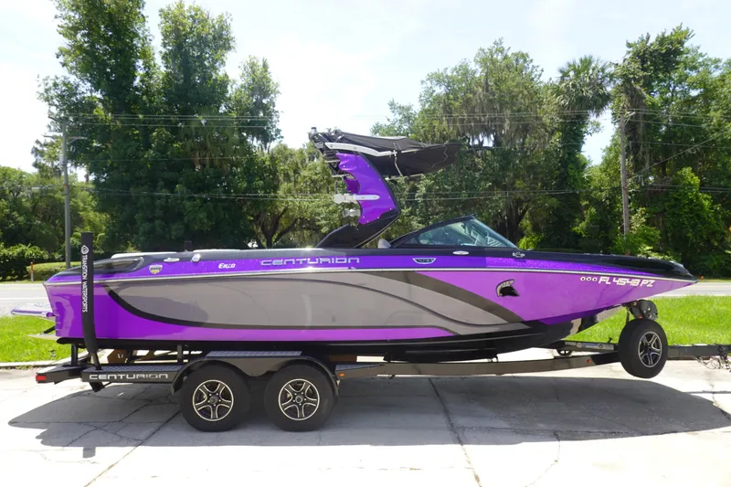 Slide: The Image of 2016 Centurion Enzo FS33 boat in vibrant purple on a trailer, parked outdoors. - 4