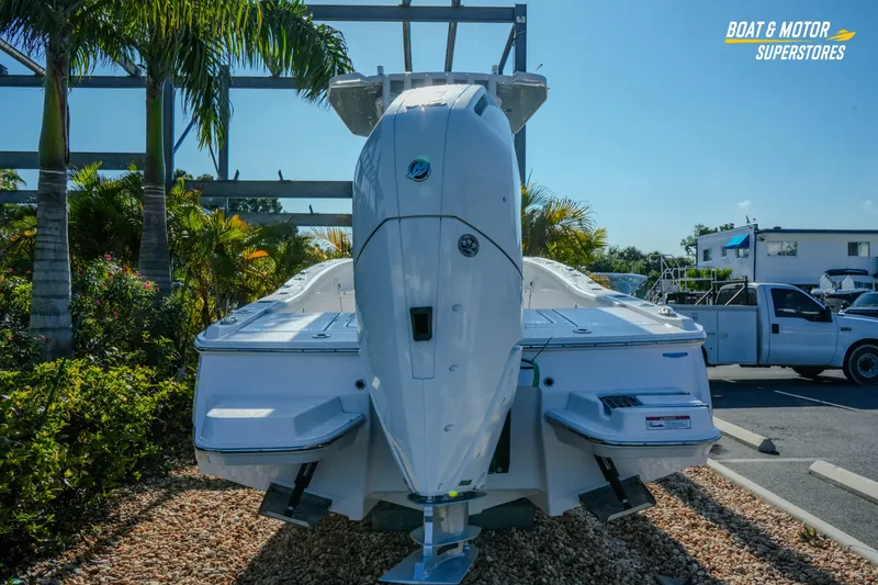 Slide: The Image of 2025 Blackfin 262 HB boat displayed outdoors with palm trees and vehicles nearby. - 4