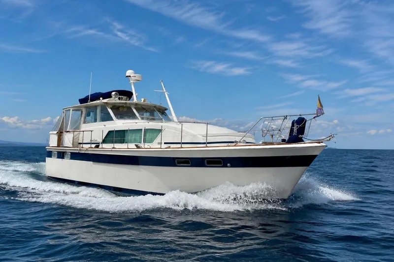 The Image of 1973 Chris-Craft 45 Commander yacht cruising on open water under a clear blue sky. - 0