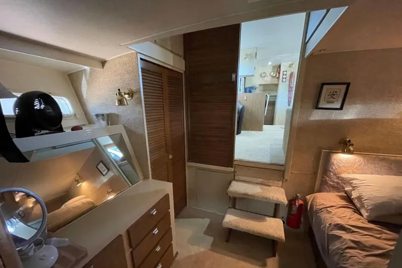 Slide: The Image of 1973 Chris-Craft 45 Commander interior with cozy bedroom, wooden accents, and soft lighting. - 19