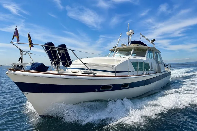 Slide: The Image of 1973 Chris-Craft 45 Commander yacht cruising on open water under a clear blue sky. - 2
