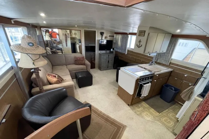 Slide: The Image of 1973 Chris-Craft 45 Commander interior with cozy seating, kitchen, and nautical decor. - 4