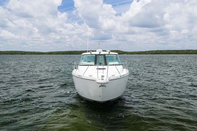 Slide: The Image of 2010 Tiara Yachts 3500 Sovran LE cruising on a serene lake under a cloudy sky. - 11