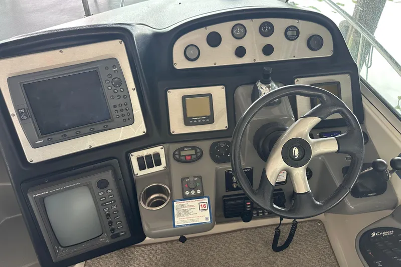 Slide: The Image of Control panel of a 2005 Cruisers Yachts 400 Express with steering wheel and navigation instruments. - 11